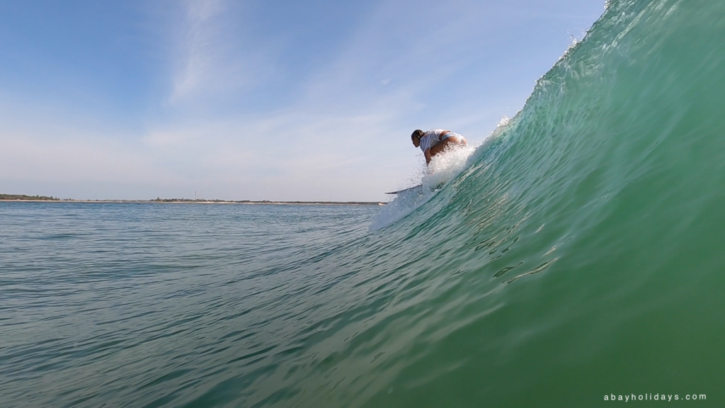 Surfer riding beside a rising wave